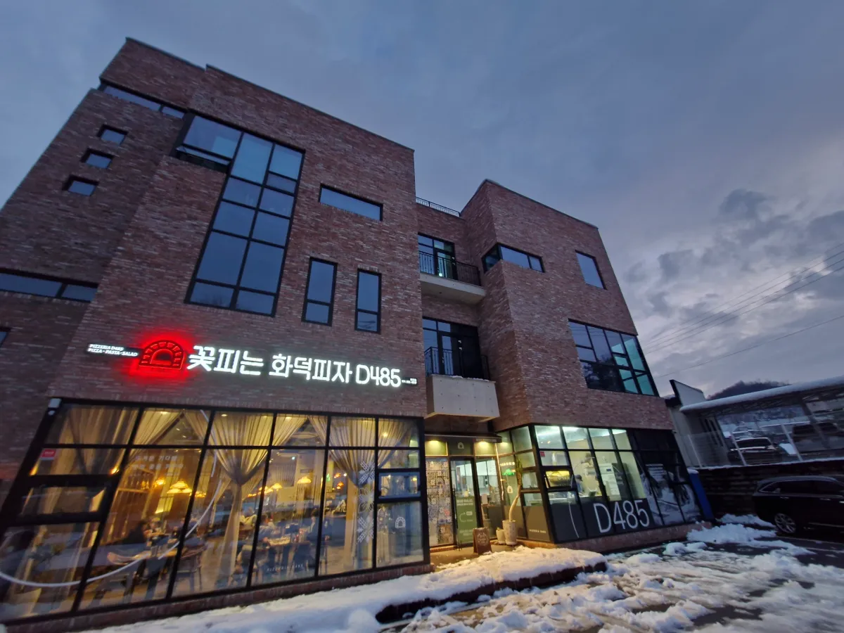 갈색벽돌의-신축건물에-화덕피자-음식점이-영업하고-있다