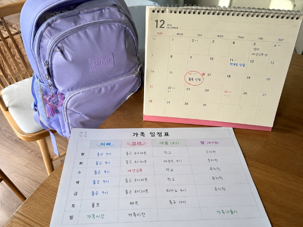 가족 일정표와 초등학생 책가방을 보며 돌봄교실 신청 일정을 준비하는 모습