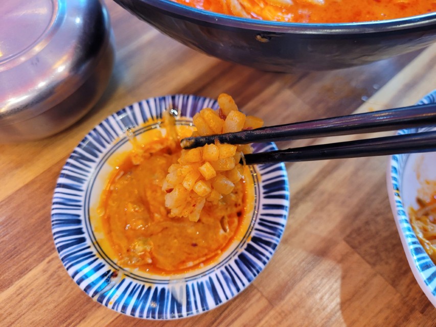 마라탕 재료를 소스에 찍어 먹는 모습