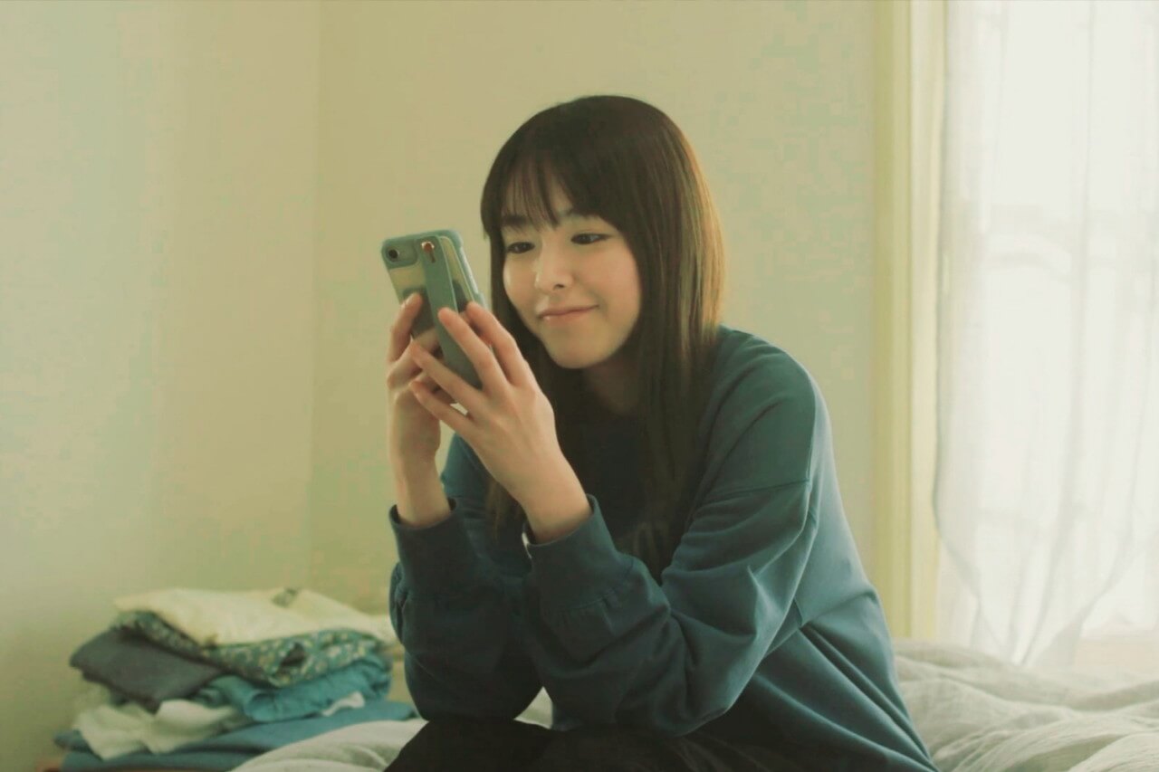 핸드폰의 문자 메시지를 보며 미소를 짓는 이이즈카