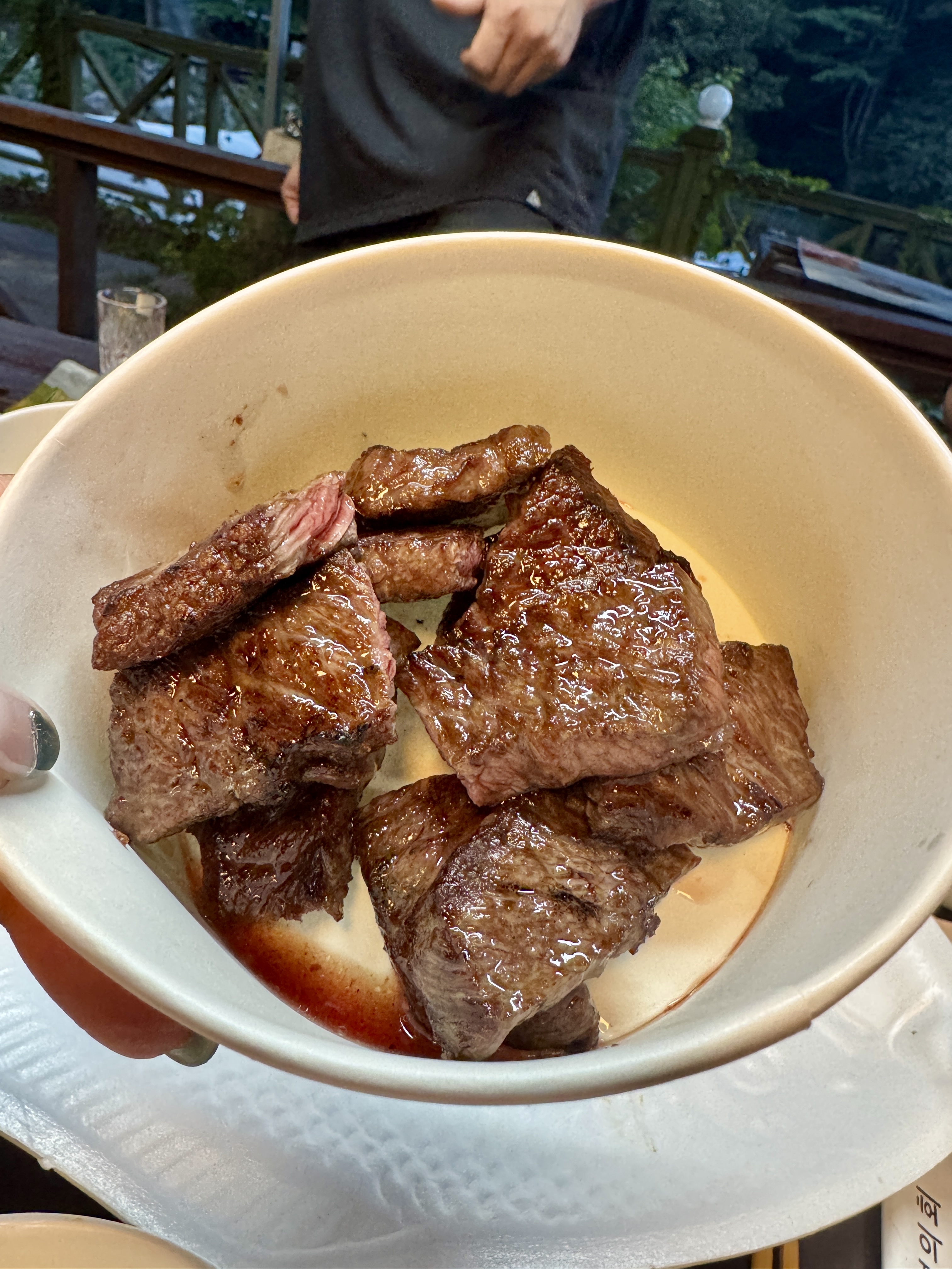 그릇 안에 담긴 지글지글 구워진 한우. 기름기와 육즙이 반짝이며 고소한 향이 전해지는 듯하다.