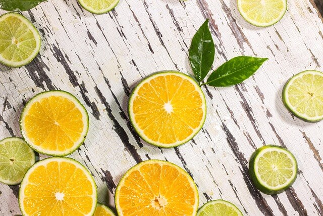 나무 판자 위에 여러 개의 레몬이 반 갈려져 있는 모습이 있음