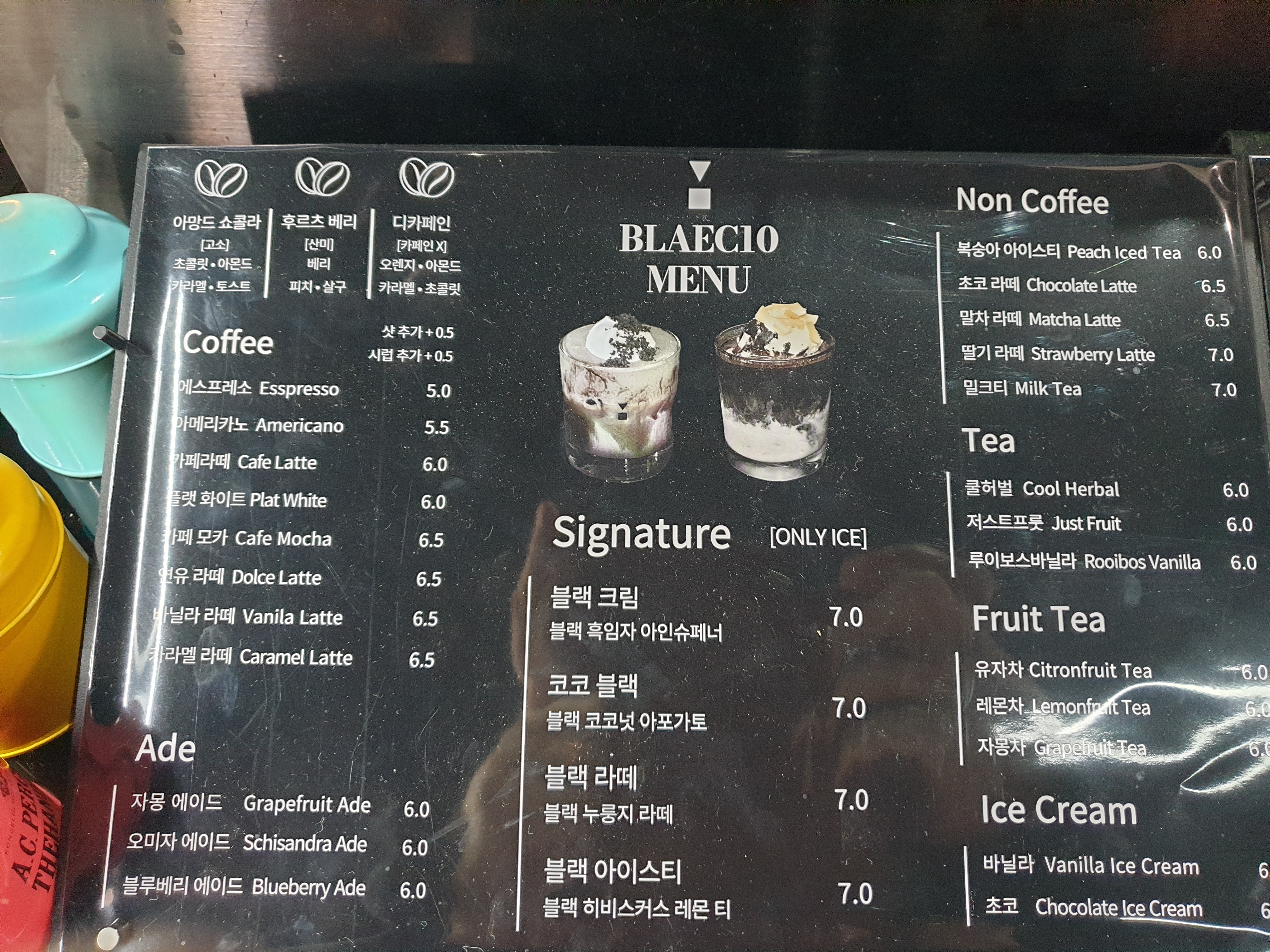 검은색 바탕 메뉴판에 커피, 에이드, 시그니처, 논 커피, 티 메뉴가 적혀있다.