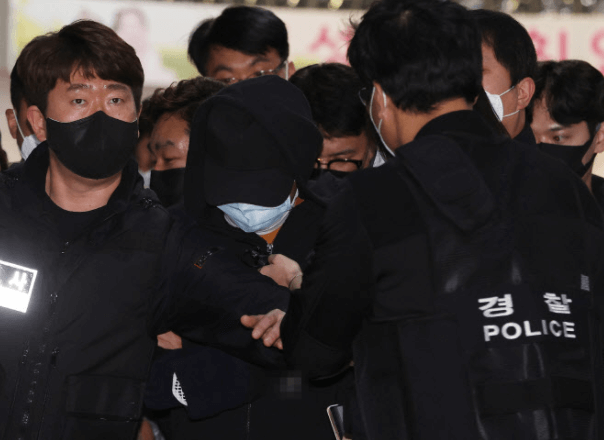 경찰들에 둘러쌓여있는 가해자