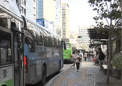 버스 정류장에 버스가 정차 중인 장면