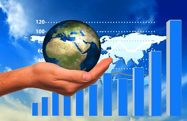 파란 화면 배경에 사람 손이 있고 손바닥 위에는 동그란 지구모형을 들고 있다. 뒤에는 파란색 막대 주식 그래프들이 여러개 있다.