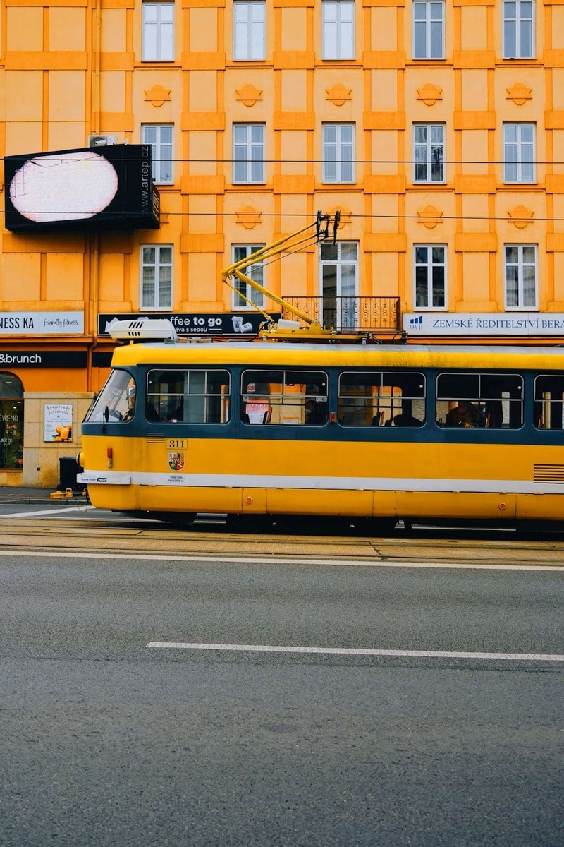 선명한 노란색 트램이 달리는 플젠 시내 거리 모습