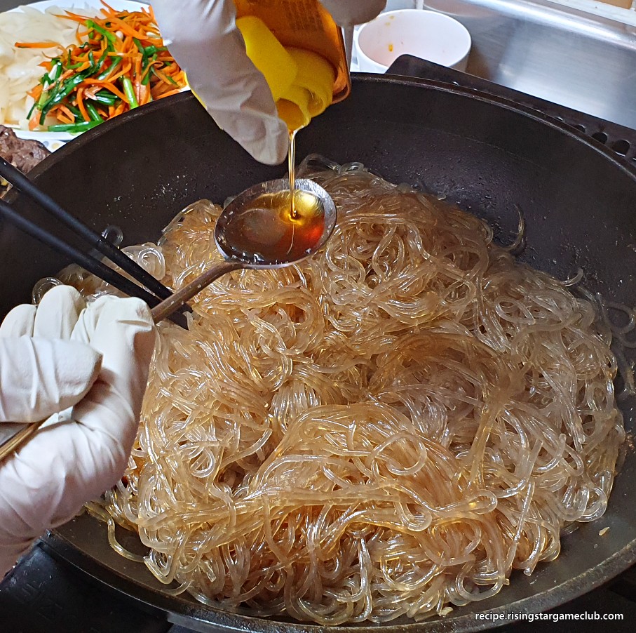 잡채에 들어갈 볶은 당면에 참기를을 넣어주는 사진