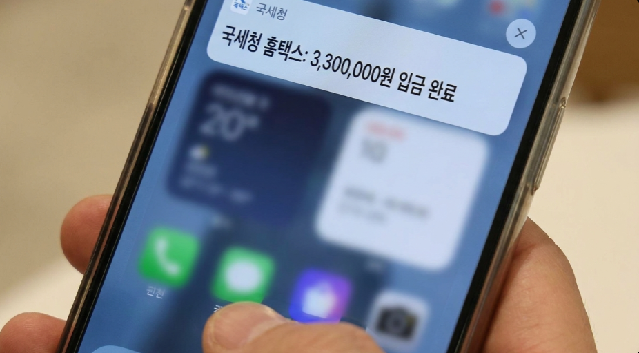 스마트폰 화면에 입금 알람이 뜬 것을 보고 기뻐하는 직장인