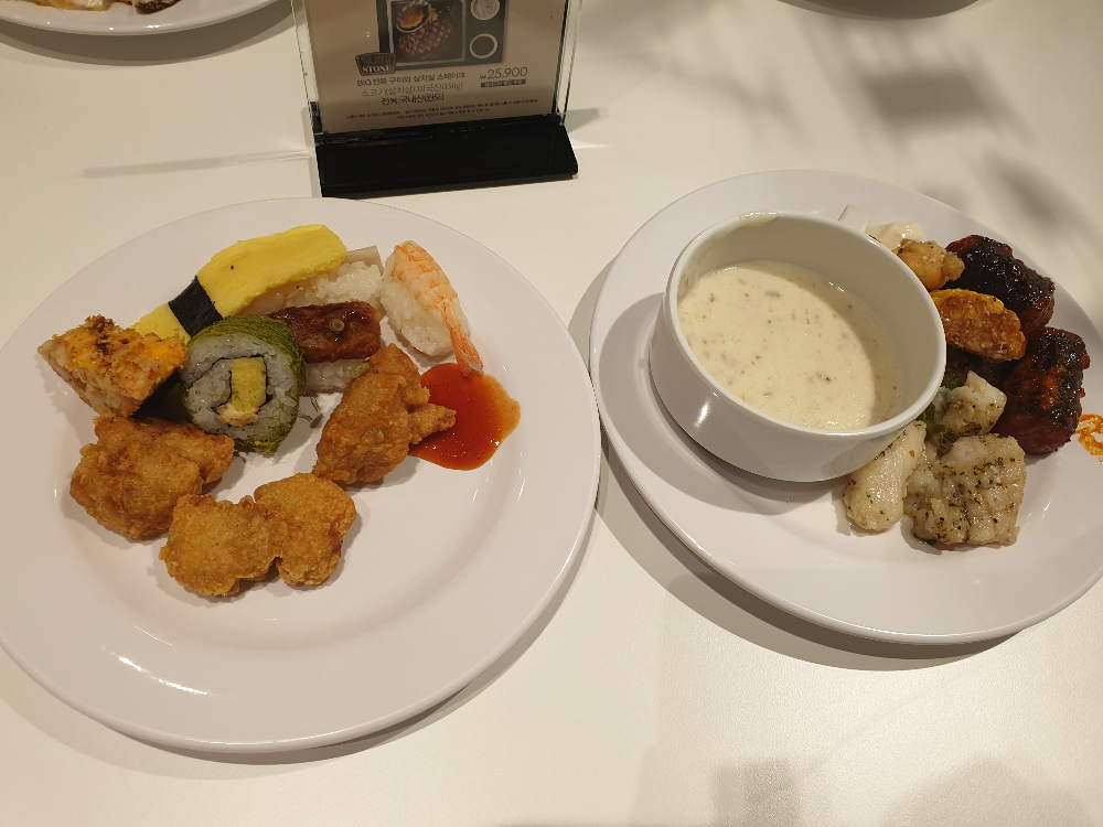 두 개의 접시와 한 개 스프. 접시에는 다양한 음식이 놓여 있다.