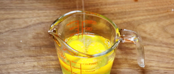 계란 3알을 푼 후 꽃소금 두 꼬집을 넣고 있습니다 