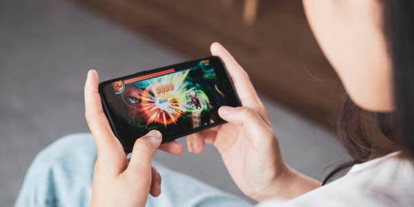 스마트폰으로 모바일 액션 게임을 즐기는 사람