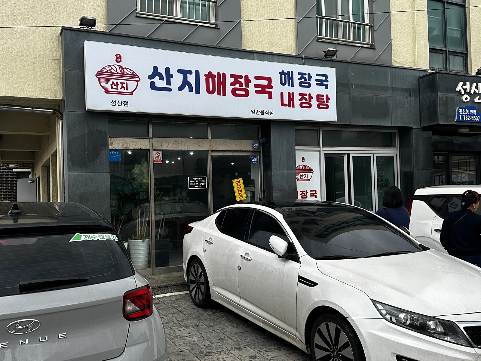 제주산지해장국-외부-깔끔한흰색바탕에-남색과-붉은색으로-글자가써져있다