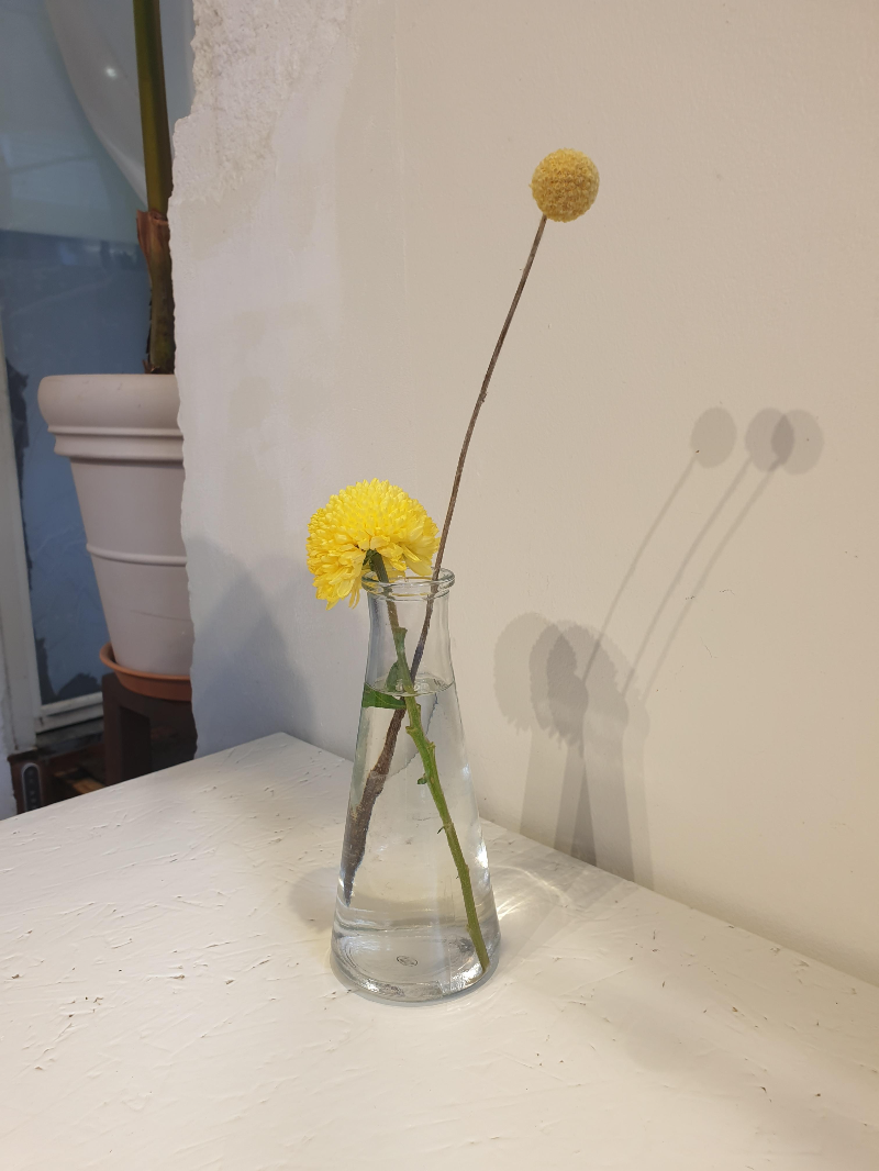 테이블 위에 놓은 노란 꽃이 든 꽃병