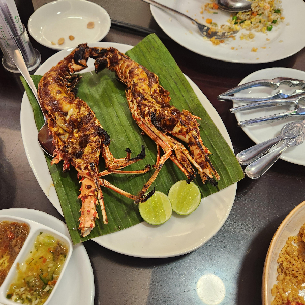 랍스터 한 마리가 반쪽으로 갈려져 구워져 나왔다. 살을 발라먹는 도구도 함께 있다.