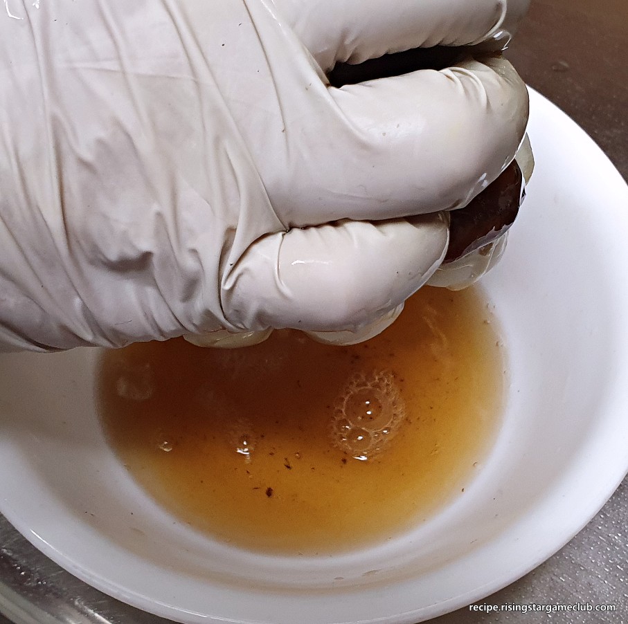 잡채에 들어갈 물에 불린 표고버섯을 손으로 꼭 짜서 물기를 제거하는 사진