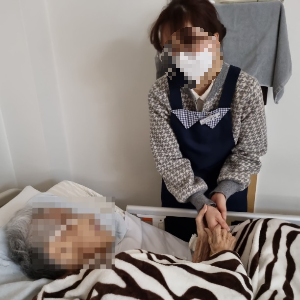 호스피스자원봉사자가 환자의 손을 따뜻하게 잡아드리고 있는 모습