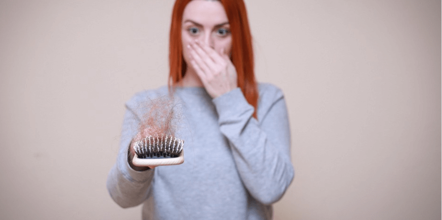 빗질 후 빠진 머리카락을 보고 놀라는 여성