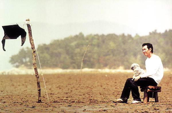 영화 속 주인공 성현이 의자에 개와 함께 앉아있는 모습