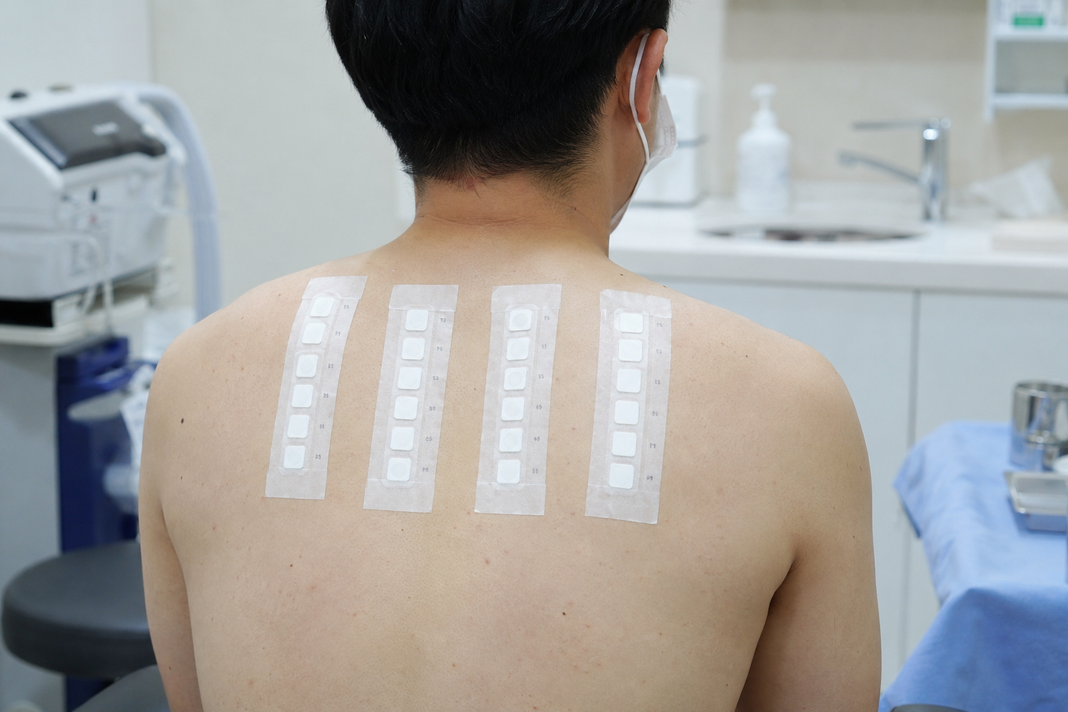 첩포검사를 위해 등에 패치를 붙인 진료실 장면