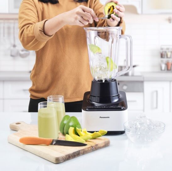 아보카도로 믹서기에 넣는 여성