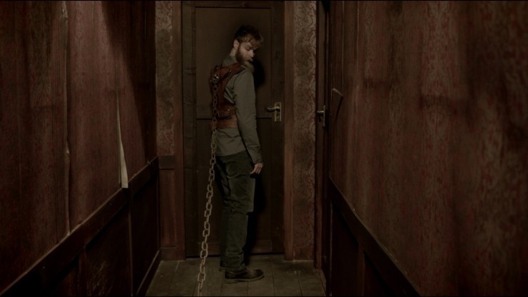 쇠사슬이 달린 옷을 바라보는 남성의 모습