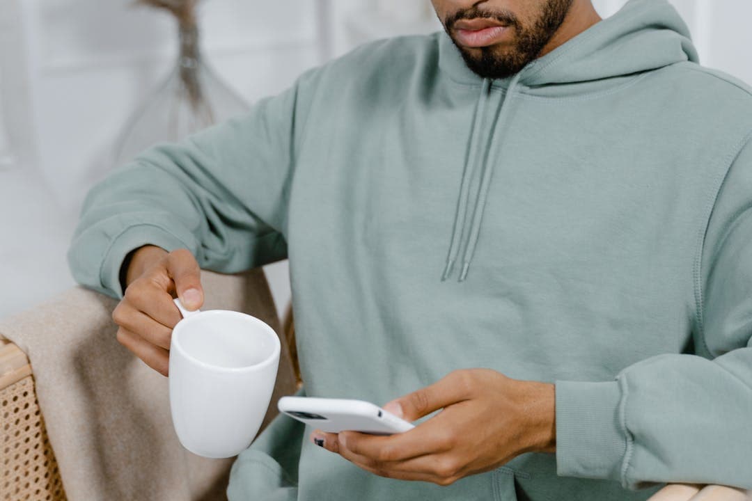 스마트폰과 커피잔을 들고 메신저 확인 중인 남성