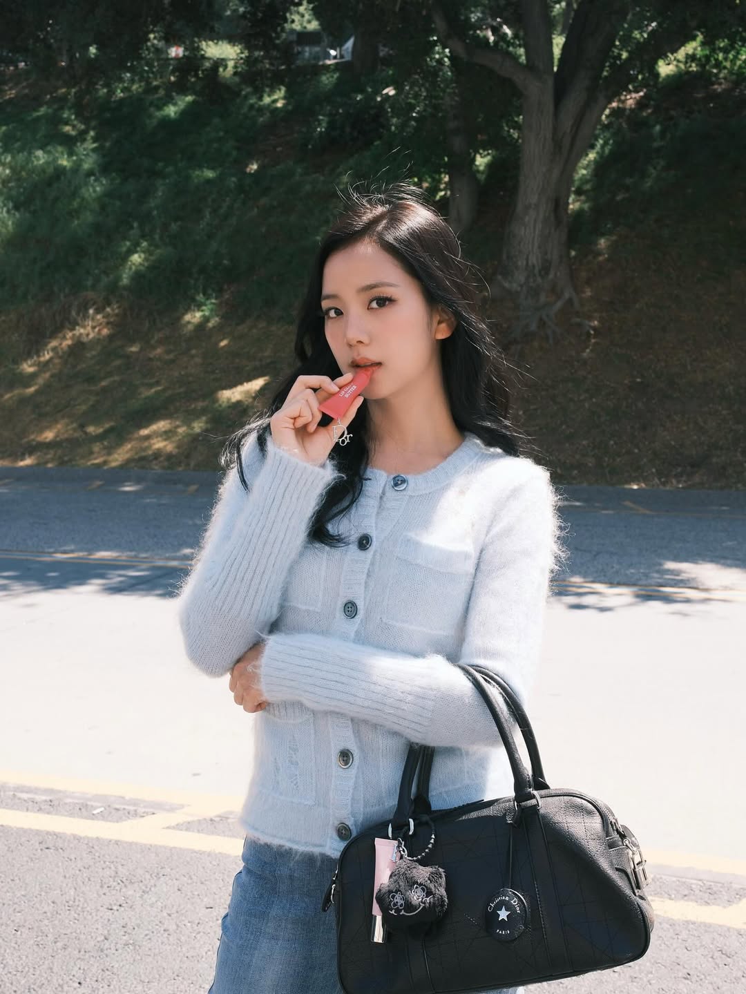 디올 가방을 들고 립밤을 바르고 잇는 블랙핑크 지수