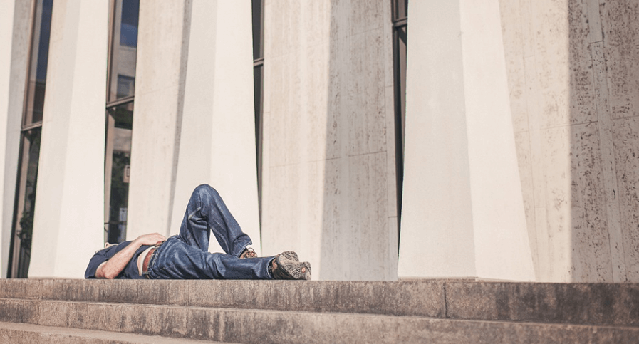 계단 위에 아무렇게 누워 잠을 자고 있는 남성