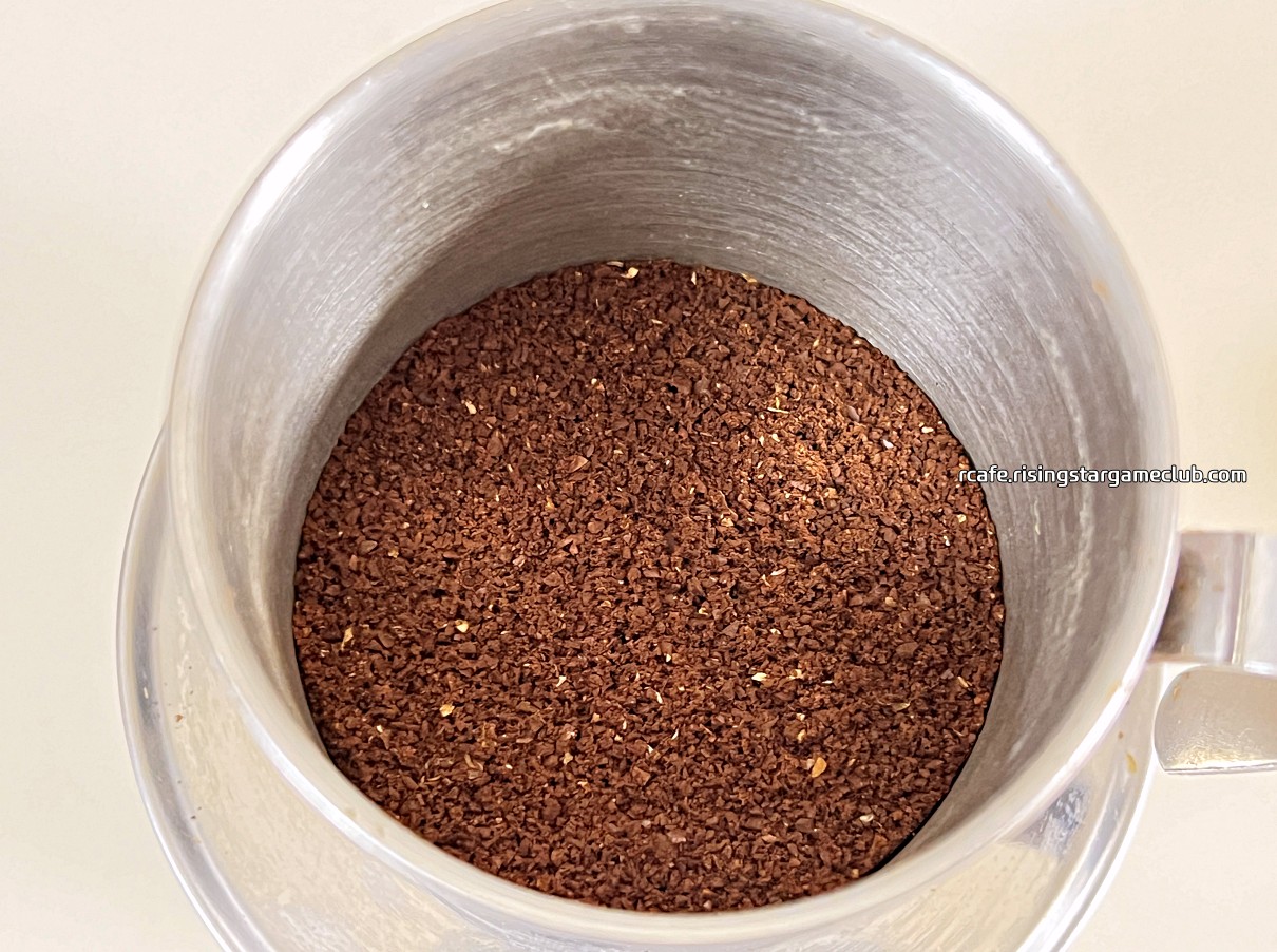 T스탠다드 케냐 오타야이차마마 AA (KENYA AA OTHAYA ICHAMAMA Single Origin) 원두를 분쇄하여 커피핀에 넣어 놓은 사진