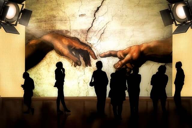 천지장조 그림의 손가락과 그림을 관람 중인 사람들의 실루엣.