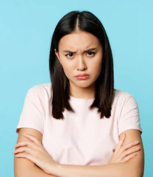 얼굴을 찡그린채로 팔짱을 끼고 있는 여성