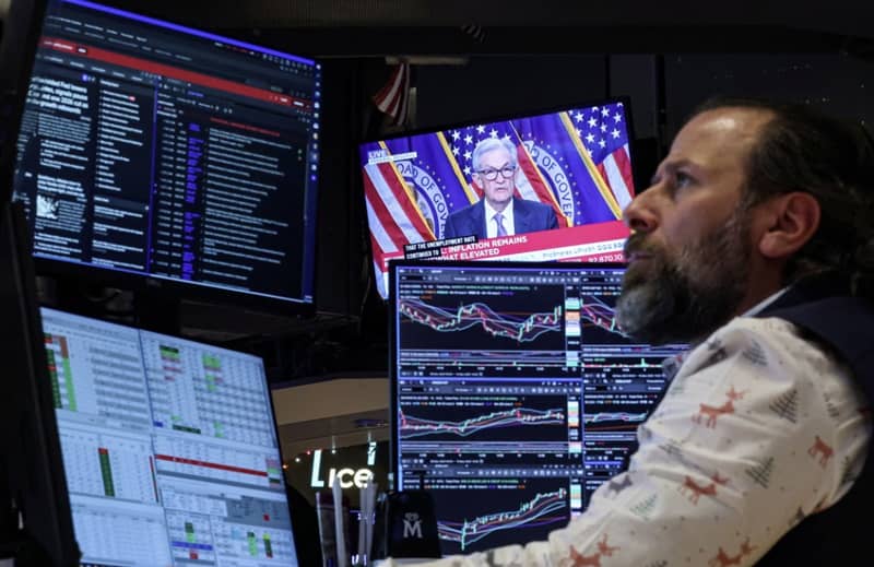 A trader works as a screen broadcasts a news conference by Federal Reserve Chair Jerome Powell. Brendan Mcdermid/Reuters