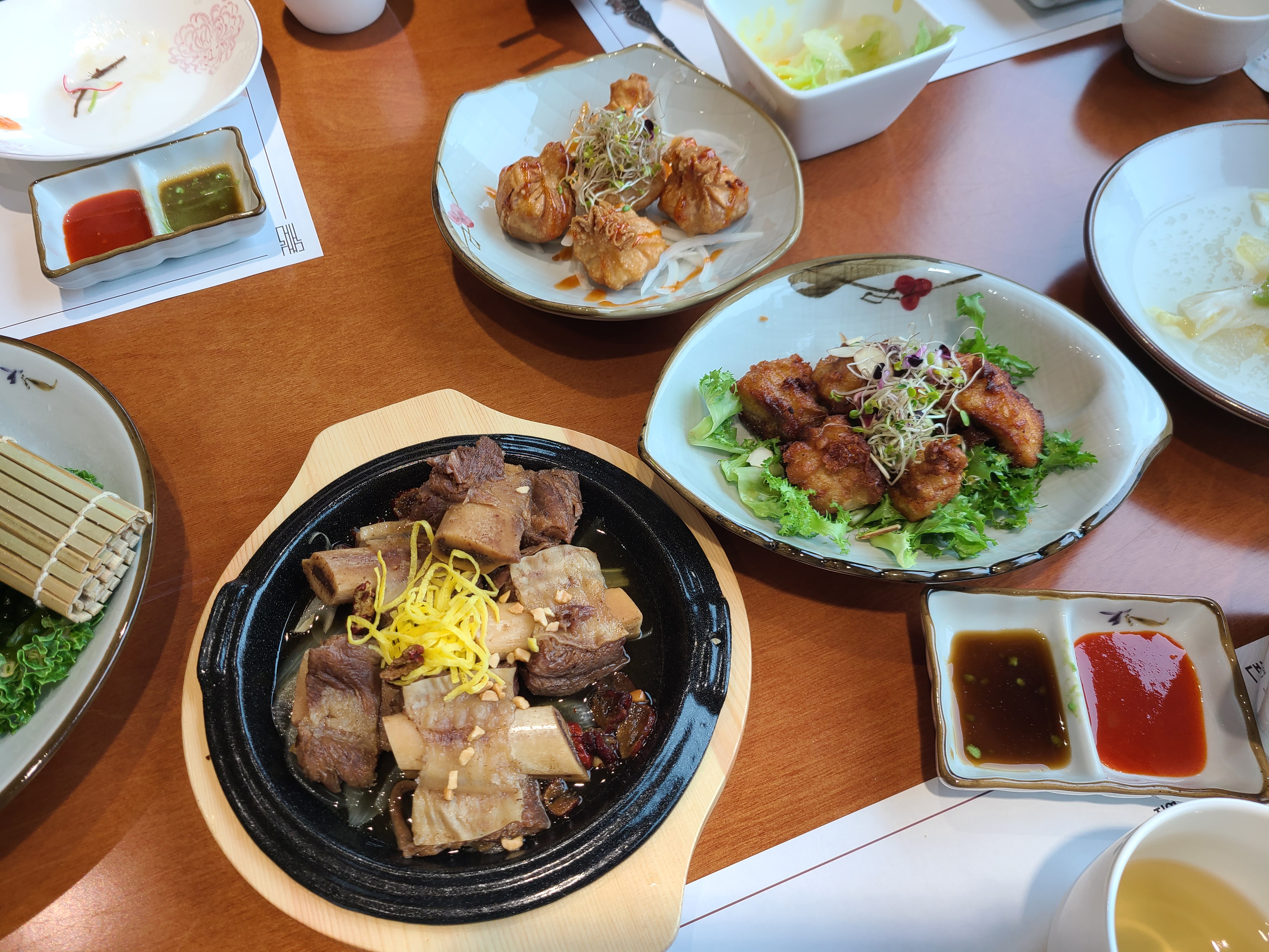 천안 대게나라 갈비찜, 치킨, 튀김만두가 담긴 접시