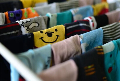 다양한 디자인의 양말들이 빨래건조대에 걸려있는 모습