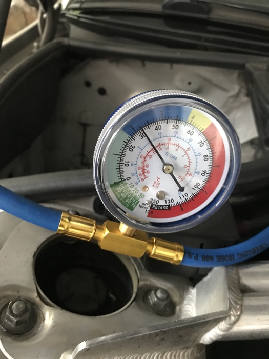 자동차 에어컨 냉매 충전 중 게이지 압력 수치를 확인하는 장면 &ndash; R134a 냉매 압력이 정상 범위에 도달했는지 체크