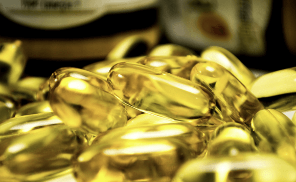 접시에 놓인 다양한 알약과 캡슐. 알부민 포함 단백질 보충제