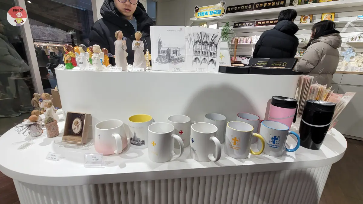 명동-명동문고-가톨릭출판사-머그컵-천사와-성인 피규어-보온병- 등이-진열