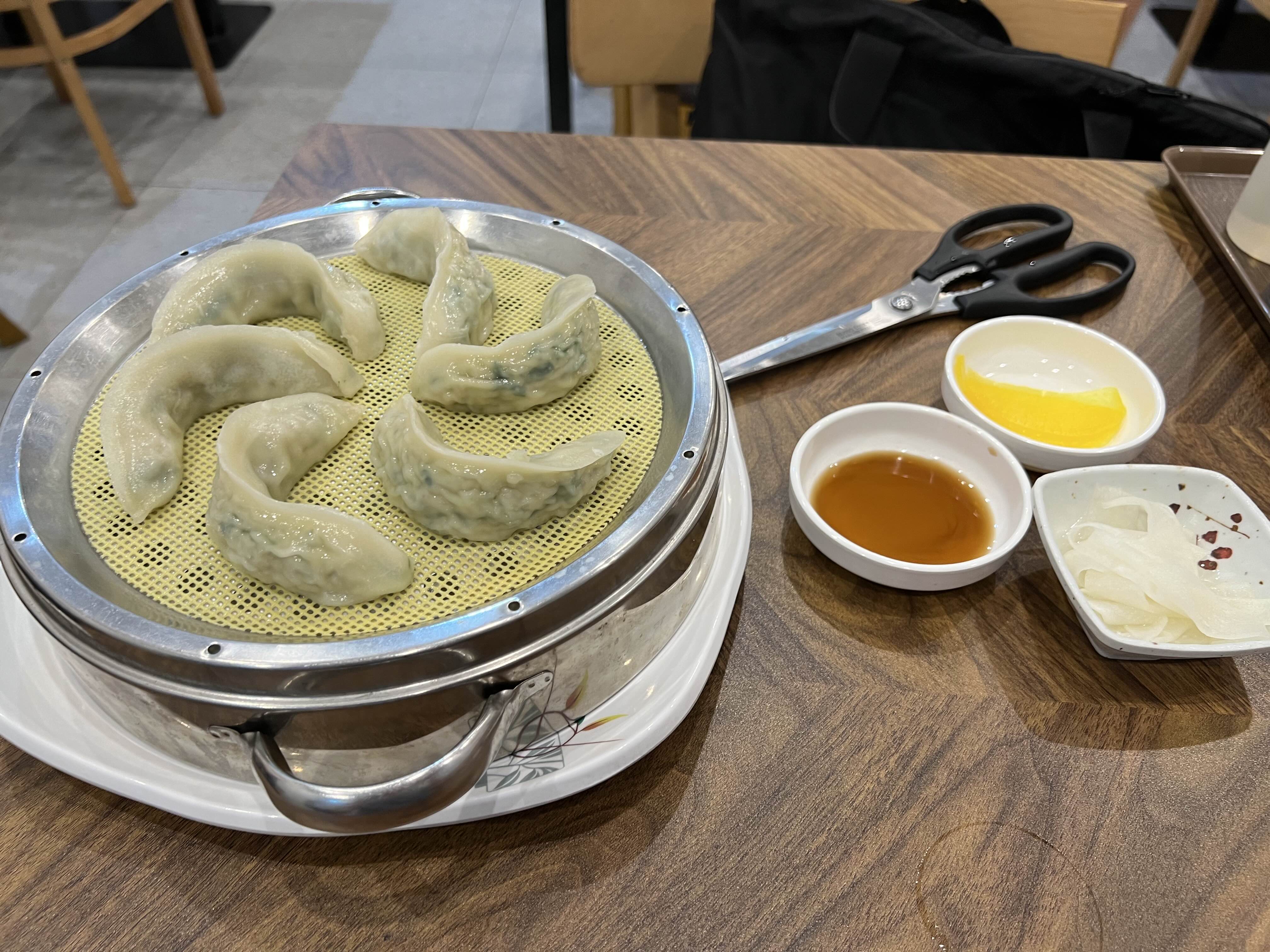 만두가 나온 테이블
만두, 가위, 간장, 단무지, 무 가 있다.