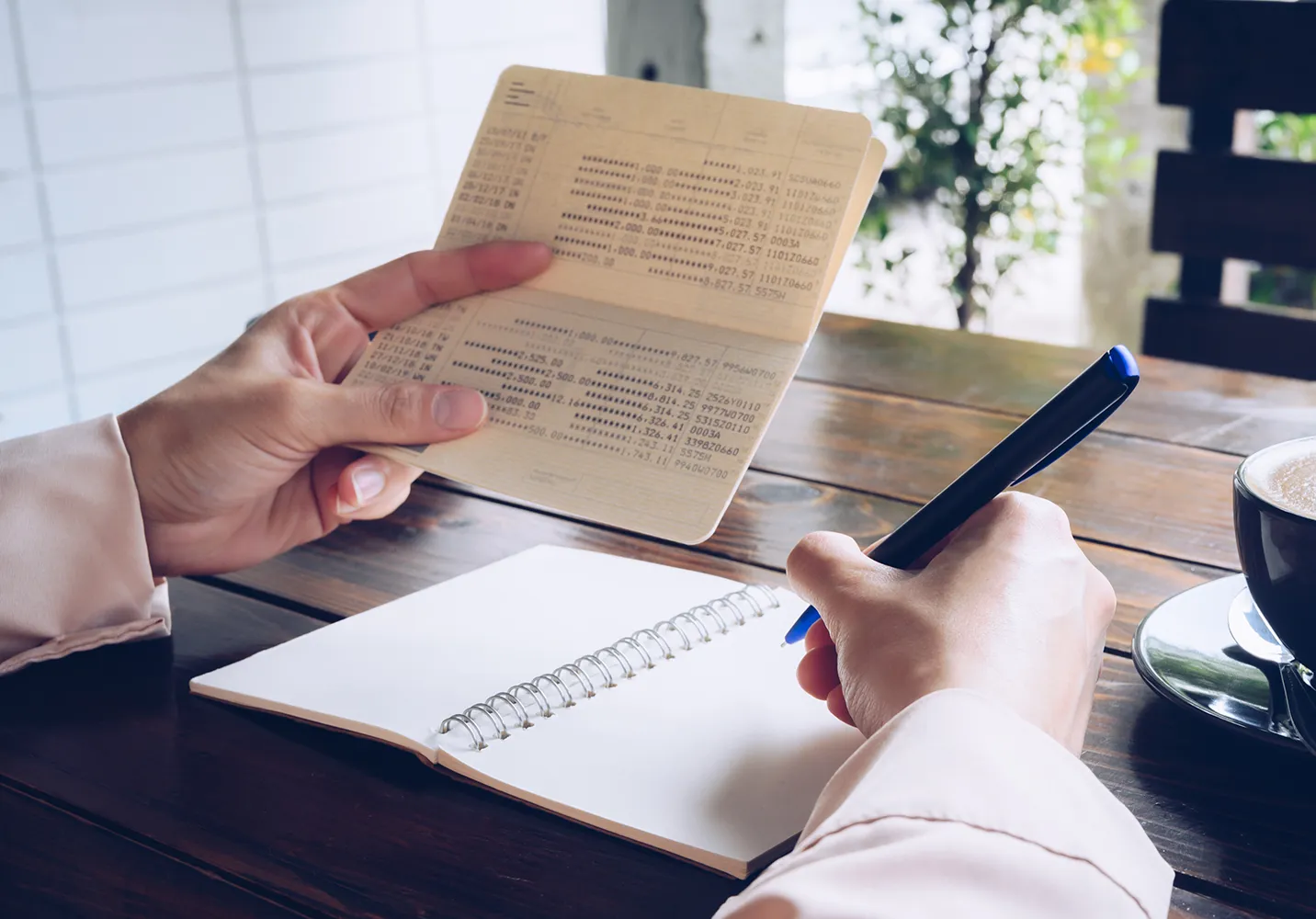 통장을-보며-가계부를-정리하는-사람