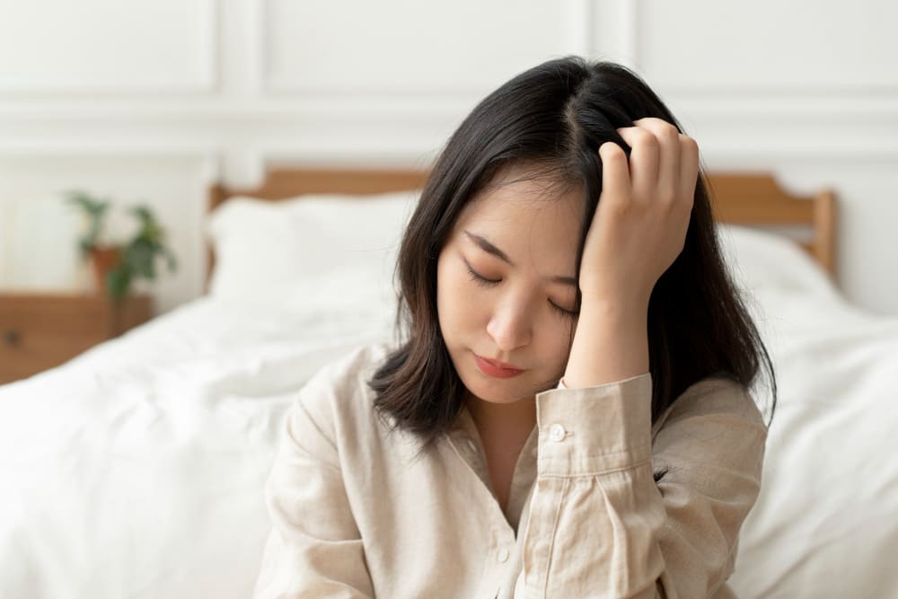눈을 감고 머리를 만지는 여성 두통