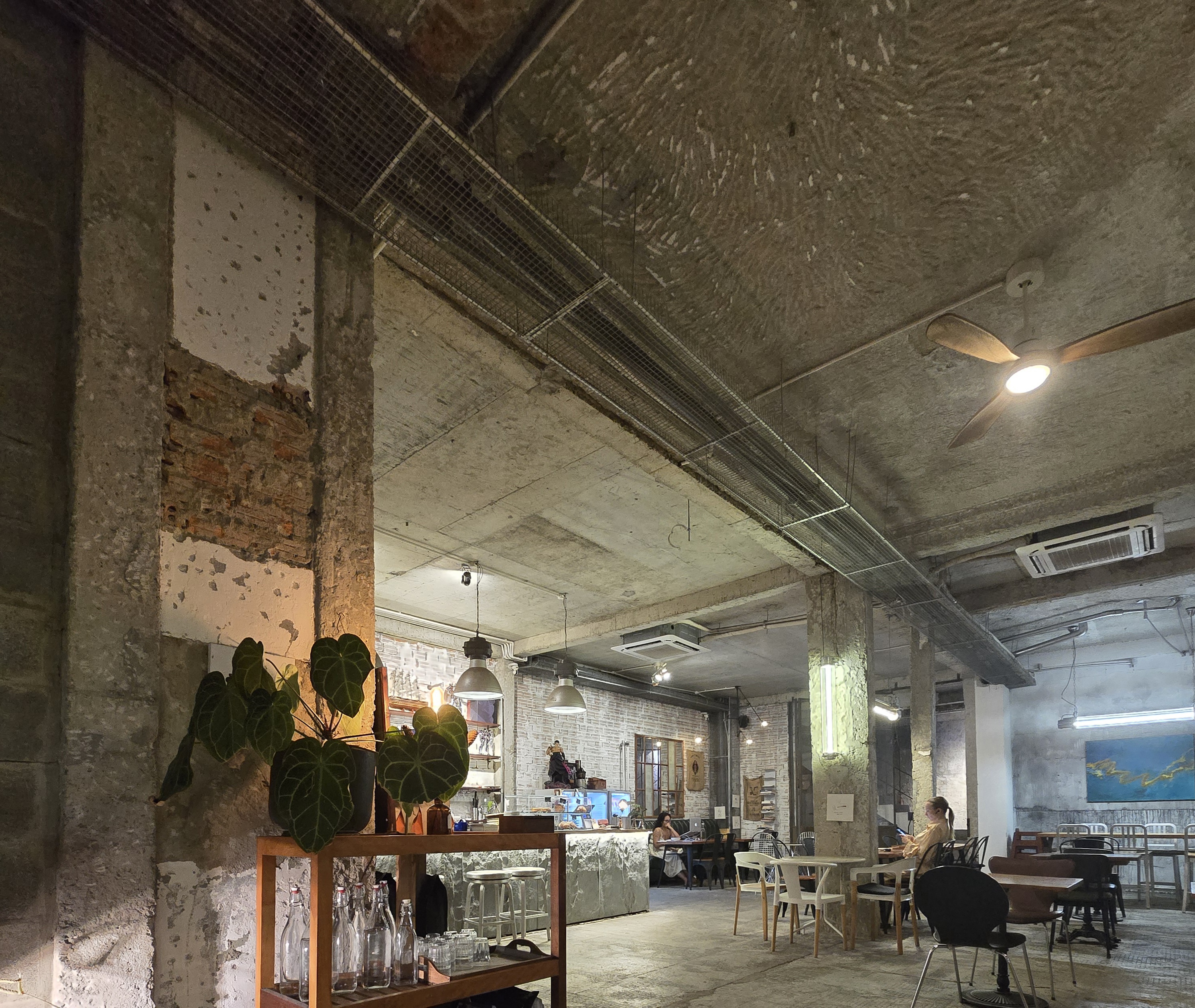 다낭의 한 인디카페 내부, 에어컨이 설치되어 있고 
식물과 감성있는 조명이 있는 조용한 글쓰기 공간