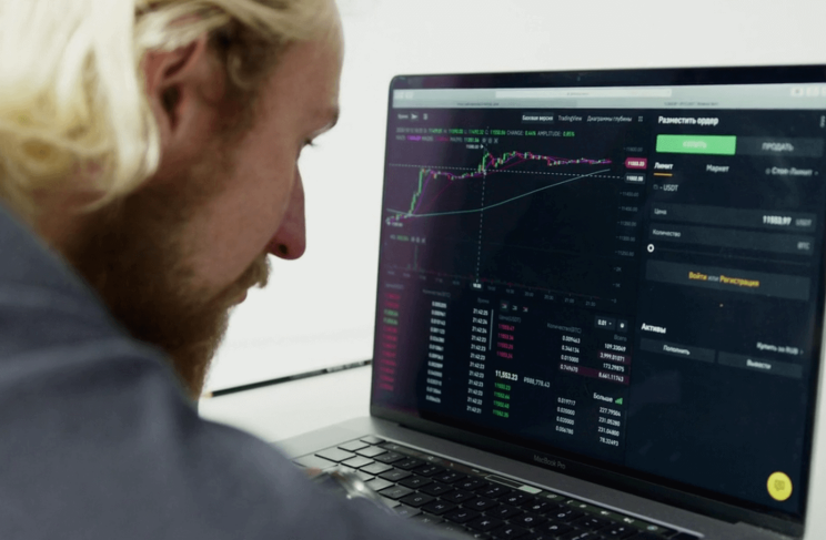 컴퓨터의 투자 종목 차트를 보고 있는 남자