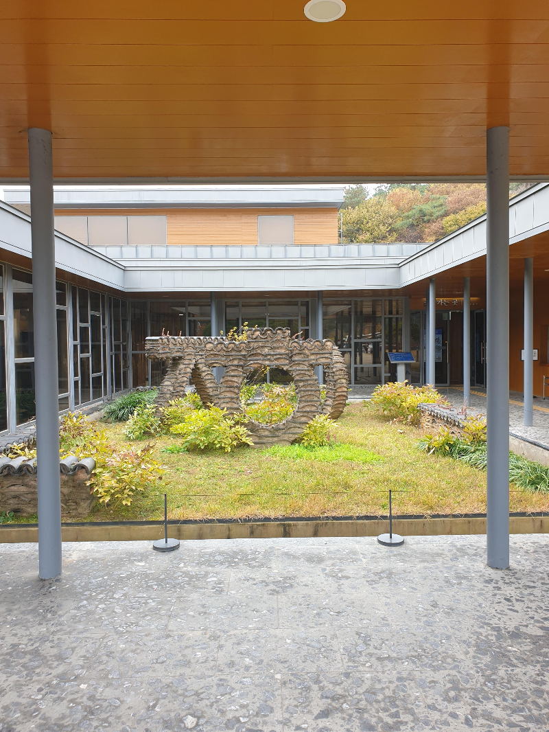 카페 중정에 놓여진 조형물, ㅈ,ㅎ,ㅇ 으로 만든 조형물이 잔디밭위에 있다.