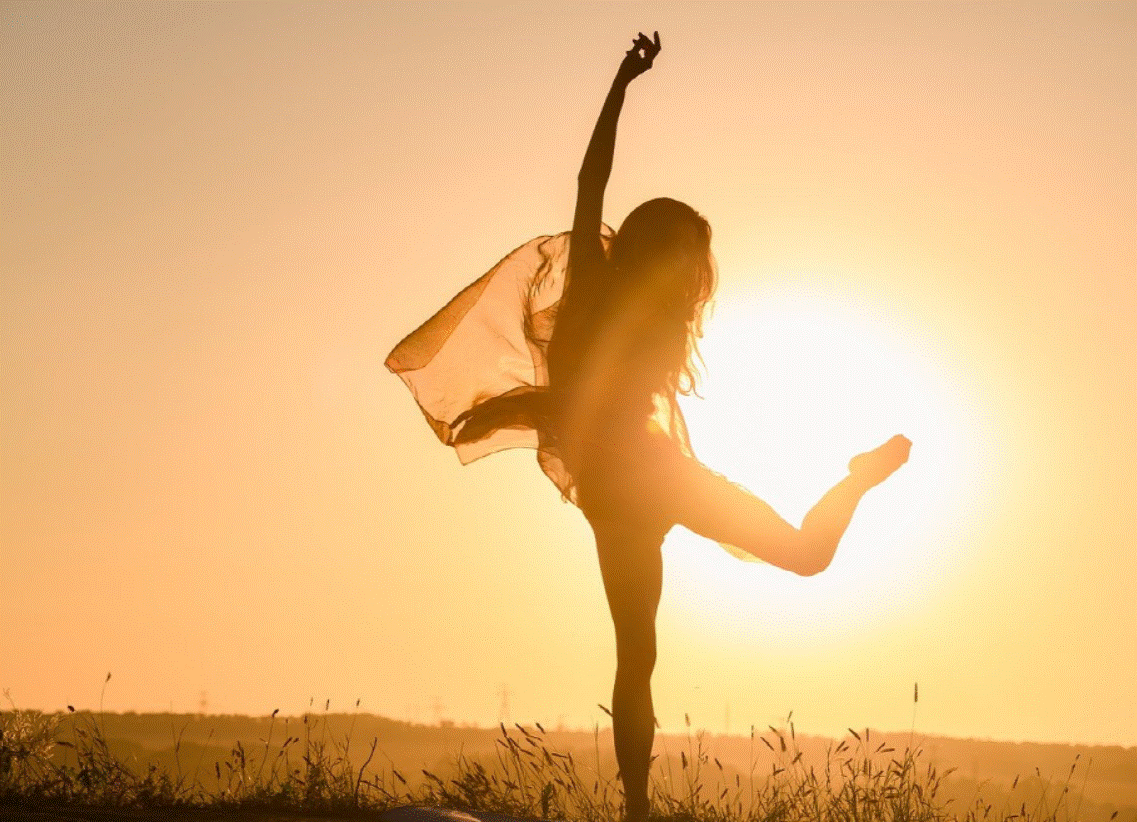 한 여성이 일몰 배경으로 춤추는 사진