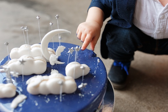 아기가 장식 케이크를 만지고 있다.