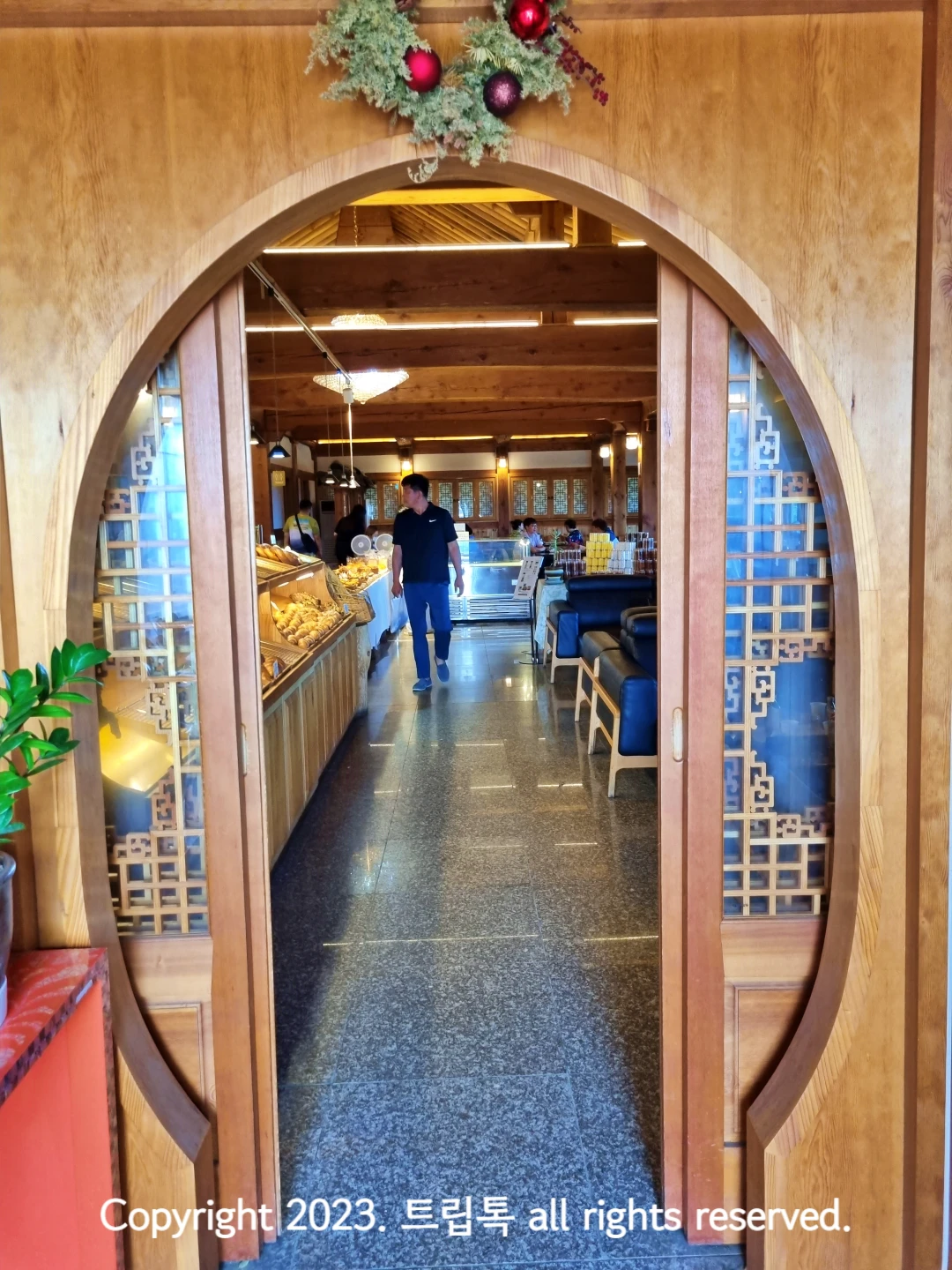 나무로 만든 미닫이 문이 열려있고 그 안에 회색대리석 바닥과 실내의 모습이 보인다