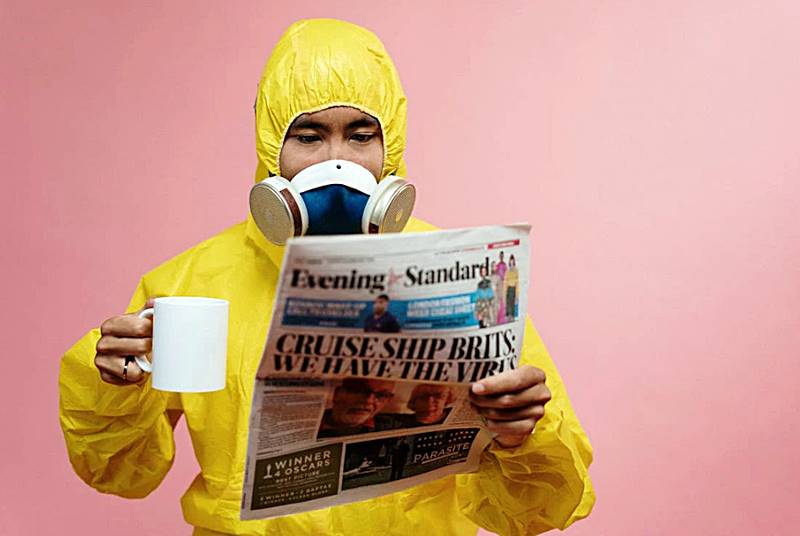 마스크와-보호장비를-착용하고-신문을-보는-모습