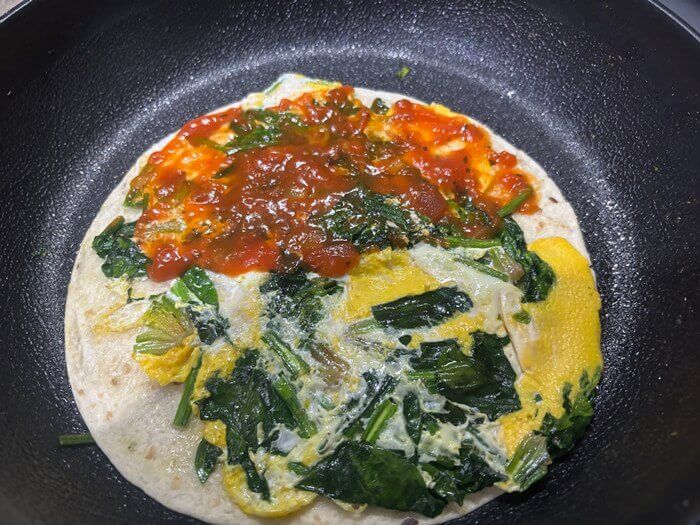 익은 계란과 시금치 위에 발린 토마토소스