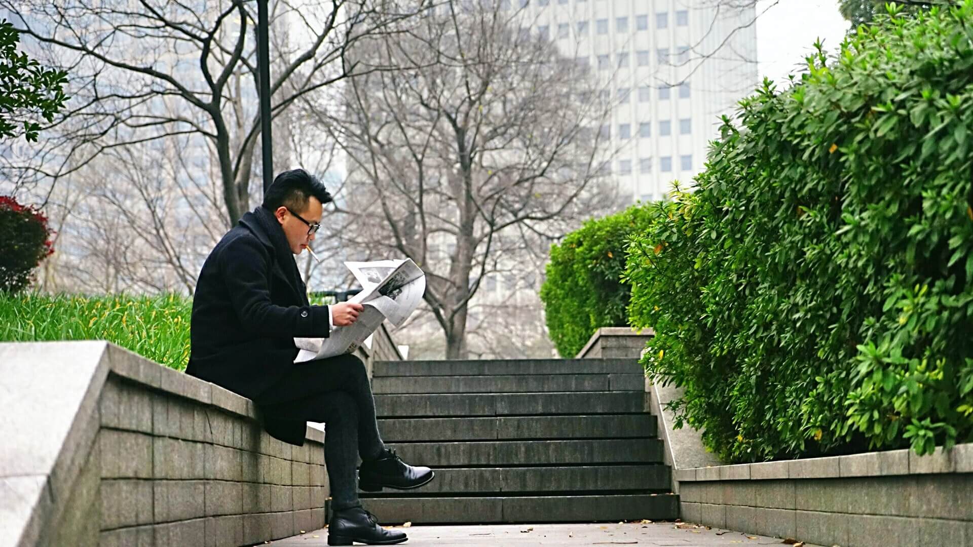 중국에서 한 남자가 앉아서 책을 보고 있는 장면